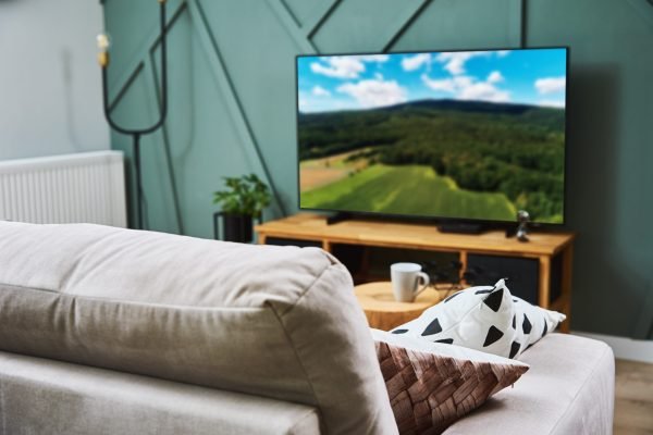 Modern interior of room with sofa, furnitures and TV set Interior of room with sofa, furnitures and TV set. Modern home decor. Place to relax on sofa with blanket